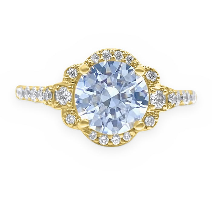 Yellow gold ring with a round pale blue stone in a diamond halo with three-stone accents