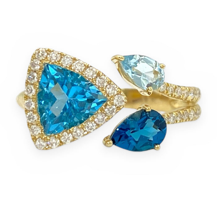 Yellow gold bypass ring with a trillion blue topaz in a diamond halo and pear topaz accents